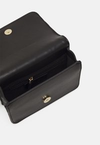 Borsa in pelle nera con una superficie liscia, caratterizzata da una forma arrotondata e una chiusura a bottone a pressione dorata. Include una tasca interna con zip.