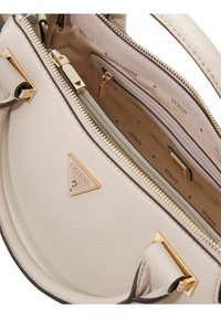 Sac à main beige clair en cuir texturé, équipé de ferrures dorées, d'un logo triangulaire, et de plusieurs compartiments zippés.