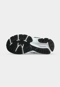 Σόλα αθλητικού παπουτσιού New Balance με ασπρόμαυρα σχέδια πέλματος, που διαθέτει υφασμένες επιφάνειες πρόσφυσης και χαρακτηριστικά στοιχεία της μάρκας.
