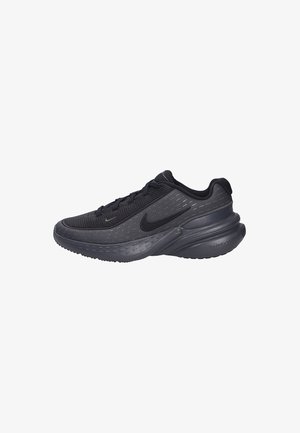 Zapatillas deportivas negras con parte superior de malla texturizada, cuello acolchado y suela de goma. Presentan sutiles acentos reflectantes y un perfil aerodinámico.