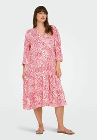Abito rosa a fantasia con scollo a V, maniche a tre quarti, gonna a balze e tessuto leggero. Il design include motivi geometrici.