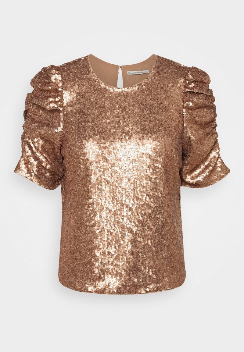 Bronze pailletbluse med korte, puffede ærmer, rund halsudskæring og åbning bagpå med nøglehul. Glat tekstur med reflekterende pailletter.