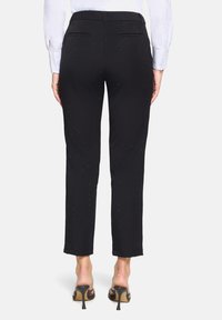 Zwarte broek met een slim fit, met een zachte textuur en subtiele sparkles; inclusief twee achterzakken en een enkel-lengte snit.