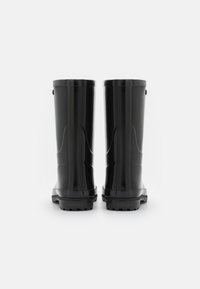 Bottes en caoutchouc noires imperméables avec une surface lisse, une semelle texturée et des rainures verticales sur les côtés, présentant un design de hauteur mi-mollet.