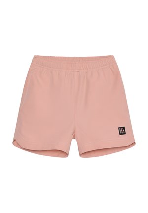 Hellrosa Shorts aus weichem Stoff mit elastischem Bund, zwei Seitentaschen und einem schwarzen Logoschild auf der unteren linken Seite.