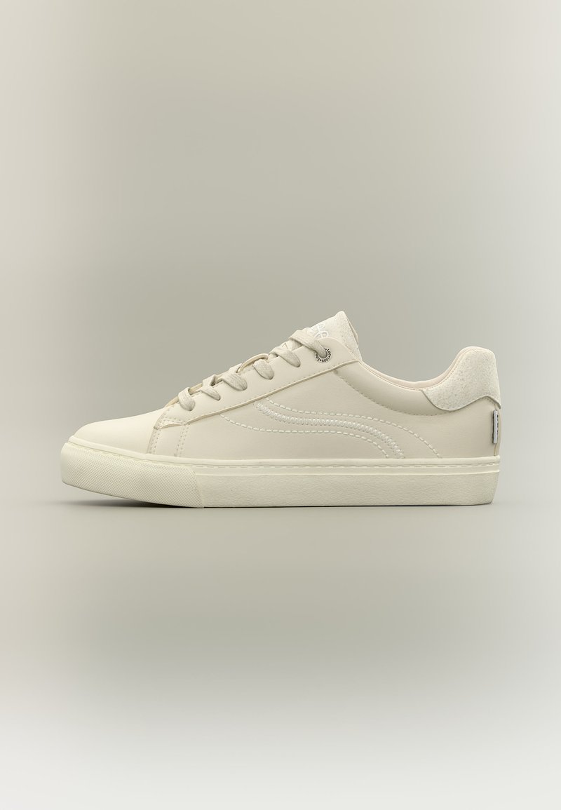 Μπεζ αθλητικό παπούτσι χαμηλού ύψους με δέσιμο κορδονιών, ραμμένο κυματιστό σχέδιο στο πλάι και επενδεδυμένο κολάρο, πάνω σε απλό ουδέτερο φόντο.