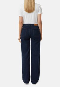 Jeans a gamba larga blu scuro con vita alta, dotati di un'etichetta in pelle color cuoio sul retro e due tasche posteriori.