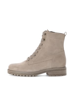 Bottines en suède beige avec un bout rond, un laçage à l'avant et une semelle en caoutchouc texturée. Comprend des coutures décoratives et une languette à l'arrière.