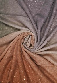 Tessuto texture con una gradazione dal viola al marrone, caratterizzato da punti metallici sparsi sulla superficie. Materiale morbido e leggero.