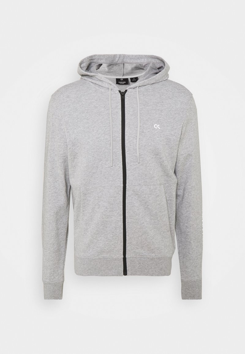 Sweat à capuche gris clair zippé avec poches avant, cordons de capuche ajustables et petit logo CK blanc sur la poitrine gauche.