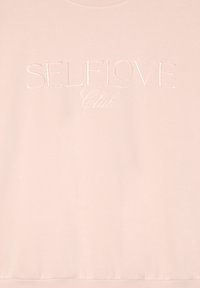 Jasnoróżowy sweter z haftowanym napisem "Klub SAMOZMIŁOŚCI". Posiada okrągły dekolt i ribbowany dół. Miękka tekstura, casualowy design.