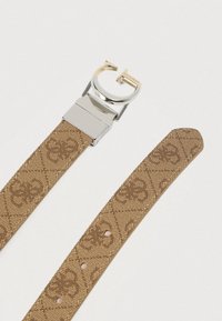 Καφέ ζώνη με μοτίβο και αγκράφα από ασημί μέταλλο. Διαθέτει μικρές τρύπες κατά μήκος του ιμάντα για ρύθμιση μεγέθους. Υφή υφάσματος.