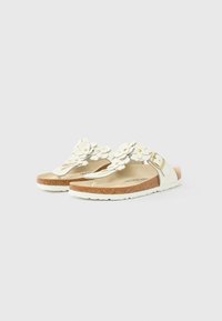 Λευκά σανδάλια τύπου thong με λουλουδάτα διακοσμητικά, μεσαία σόλα από φελλό και λευκή εξωτερική σόλα με υφή. Λεπτομέρεια με αγκράφα στο πλάι για ρύθμιση.