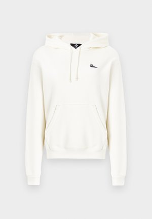 Fehér kapucnis pulóver elülső zsebbel, húzózsinóros kapucnival, bordázott mandzsettákkal és egy apró fekete logóval a mellkason. Puha pamut anyagból készült.