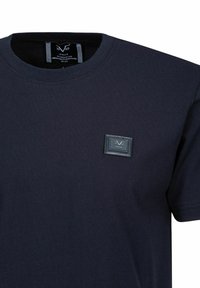 Marineblaue Baumwoll-T-Shirts mit Rundhalsausschnitt und kurzen Ärmeln, ausgestattet mit einem rechteckigen schwarzen Etikett mit eingeprägtem Logo auf der Brust.