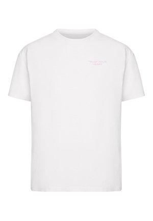 White cotton t-shirt featuring short sleeves and a crew neckline. Text “TRUST YOUR HEART” in light pink on the front.