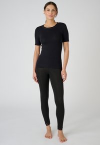Black short-sleeve top with round neckline paired with black leggings featuring lace trim at the ankles, both in a fitted style.