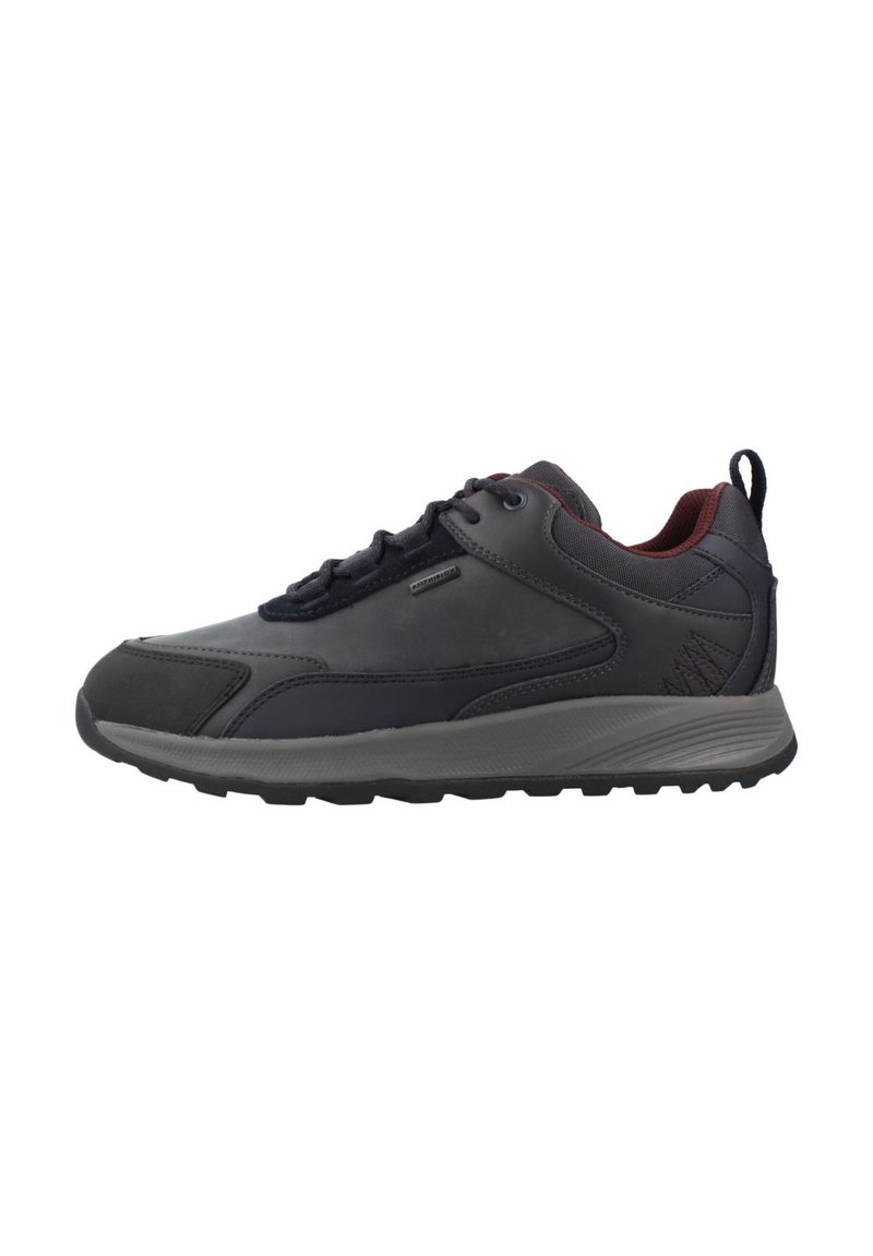 Zapatilla deportiva para hombre en azul oscuro y gris. Cuenta con parte superior sintética lisa, diseño con cordones, cuello acolchado y suela de goma texturizada.