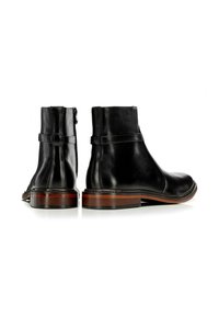 Botas de tobillo de cuero negro con un acabado suave, que cuentan con una cremallera lateral, costuras decorativas y un tacón de madera marrón contrastante.