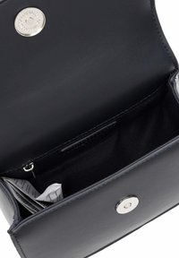 Billetera de cuero negro con textura suave, cierre de botón de presión plateado y un compartimento abierto que muestra un forro de tela oscura y papeles doblados en su interior.
