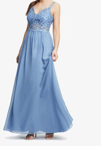 Světle modré maxi šaty s krajkovým korzetem s květinovými vzory, ramínky na tenké špagety a splývavou sukní. Hladká látka s průsvitnou vrstvou.