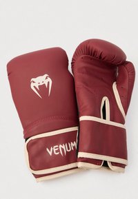 Červené boxerské rukavice z umelého koženého materiálu, s bielym logom hada, béžovými detailmi a vystlanou štruktúrou pre ochranu.