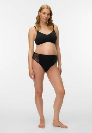 Melnas krūšturis grūtniecēm ar apaļu kakla izgriezumu un vieglu audumu, kombinēts ar melnām augsta vidukļa biksītēm ar mežģīņu sānu akcentiem.