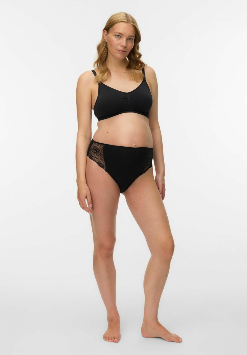 Melnas krūšturis grūtniecēm ar apaļu kakla izgriezumu un vieglu audumu, kombinēts ar melnām augsta vidukļa biksītēm ar me�žģīņu sānu akcentiem.