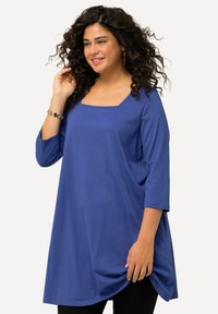 Blauwe tuniek met een vierkante halslijn, driekwartmouwen en een ontspannen pasvorm. Gemaakt van een zachte stof met een gladde textuur.