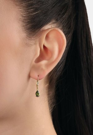 Goldene Tropfenohrringe mit einem grünen Edelstein, die an einem kleinen Ring hängen. Einfaches Design mit glatten Akzenten und einer polierten Oberfläche.