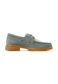 Zapato de barco de ante verde claro con parte superior de tejido beige, puntera redonda y suela de goma. Presenta ojales y detalles de costura en tono dorado.