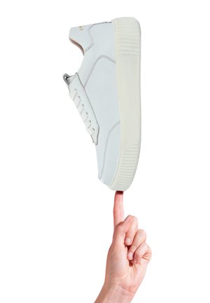 Sneaker bianca con tomaia in pelle liscia, colletto imbottito e suola in gomma leggera; presenta cuciture minime e un pannello laterale per i lacci.