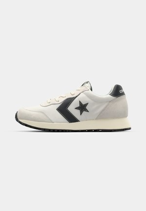 Scarpa da ginnastica bianca e grigia con logo a stella nera, punta arrotondata, design con lacci, accenti in camoscio e suola in gomma testurizzata.