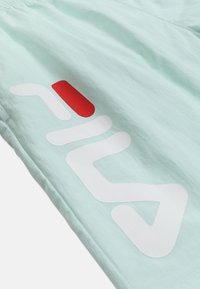 Lyseblåt stof med delvist hvid og rød fed logo tekst trykt diagonalt henover.