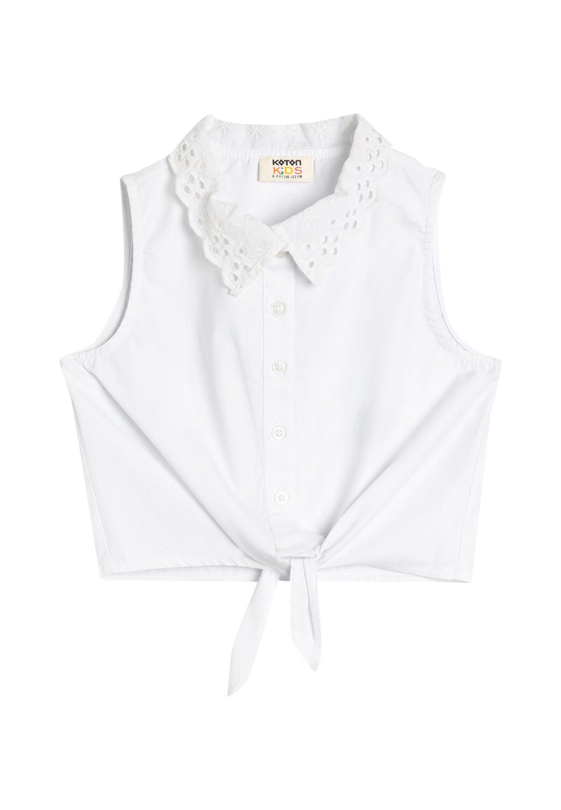Weiße ärmellose Bluse mit einem floralen Spitzenkragen, Knopfverschluss vorne und einer gebundenen Schleife am Saum. Hergestellt aus leichtem Baumwollmaterial.