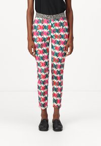 Bunte gemusterte Hosen mit einem geometrischen Design in Pink, Grün und Weiß, einem Leopardenmuster am Bund und tapered Beinen.