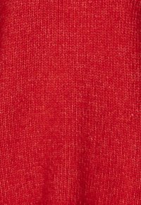 Roter gestrickter Stoff mit einer glatten Textur und einem gleichmäßigen Muster, das eine mittlere Dicke und einen leichten Glanz aufweist. Keine auffälligen Hardware-Elemente oder Akzente.