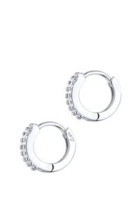 Boucles d'oreilles en argent en forme de créole présentant une rangée de petits cristaux transparents le long d'un bord, avec une finition métallique lisse et une fermeture à charnière.