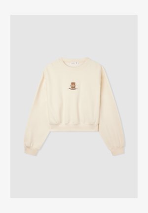 Kremowy, skrócony sweatshirt z długimi rękawami i ściągaczami. Na klatce piersiowej znajduje się brązowy haftowany miś oraz napis. Miękka tekstura.