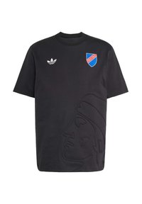 Juodas medvilnės marškinėliai su iškilusia profilio dizaino detale, balta Adidas logotipas kairiajame krūtinės pusėje ir spalvingas skydas dešinėje.