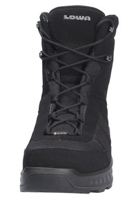 Des bottes de randonnée noires présentent une combinaison de daim et de matériaux textiles, un col rembourré, et une semelle texturée avec un système de laçage robuste.