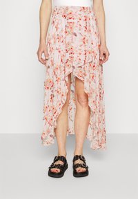 Jupe maxi florale en rose clair, avec un ourlet asymétrique, un design à volants et un mélange de motifs orange et rouge. Assortie avec des sandales noires.