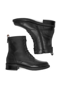 Para czarnych skórzanych botków za kostkę z sznurówkami i zamkami bocznymi, niskie, zgrubiane obcasy i uchwyty do zakładania na białym tle.