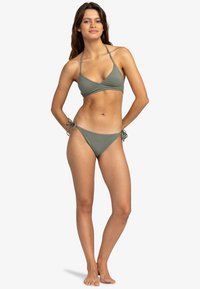 Olivgrön bikini-set med en triangulär bikinitopp med justerbara band och en knytning i sidan på byxorna, allt i ett mjukt tyg.