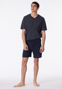 Navy V-neck T-shirt with white grid pattern, paired with solid navy shorts. Both made from soft, lightweight fabric; shorts feature an elastic waistband.