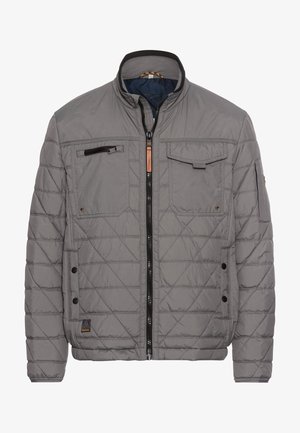 Grå quiltet jakke med opretstående krave, frontlynlås, flere lommer og kontrasterende sorte detaljer på lynlåsen og manchetterne.