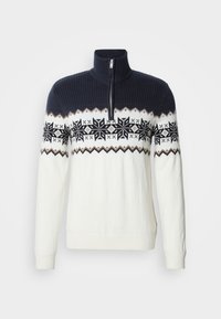 Sweter dzianinowy z zamkiem przy szyi, granatową górą i białym dołem z wzorem czarnych płatków śniegu oraz geometrycznych akcentów.