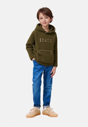 Hoodie en polaire vert olive avec une poche kangourou et des lettres métalliques. Assorti à un jean en denim bleu et des baskets beiges.