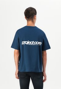Navy blue cotton t-shirt with short sleeves and a relaxed fit. Features white text "project core" and "CREATIVE DEPT." on the back.