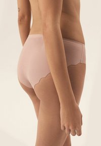 Rosa gerippte Unterwäsche mit gewelltem Rand, von hinten gezeigt. Weicher Stoff und enganliegendes Design, das die Form des Kleidungsstücks betont.